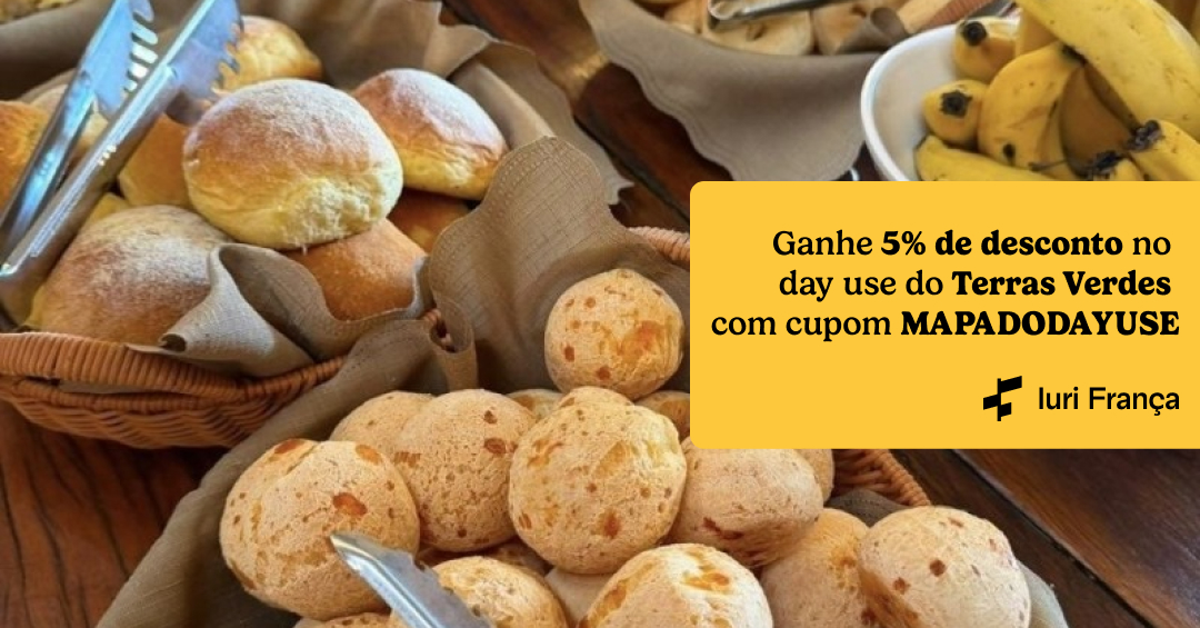 Foto de uma mesa de café da manhã com destaque para o pão de queijo. Na lateral tem um texto escrito "Ganhe 5% de desconto no day use do Terras Verdes com cupom MAPADODAYUSE"